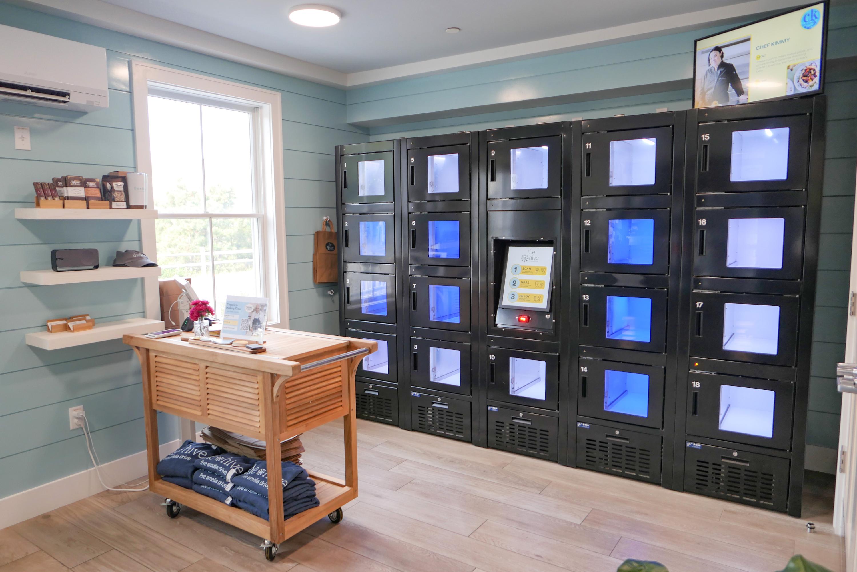The food lockers at The Hive with a wooden cart holding signage and merchandise, and shelves on the wall featuring Maker products