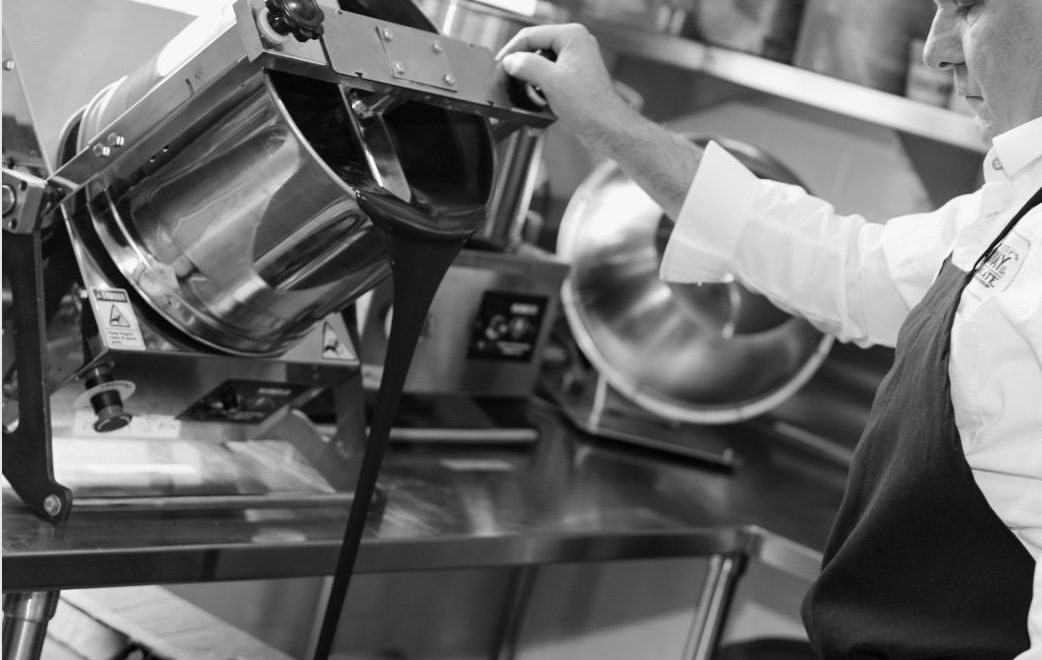 A chef working at a tilting electric kettle